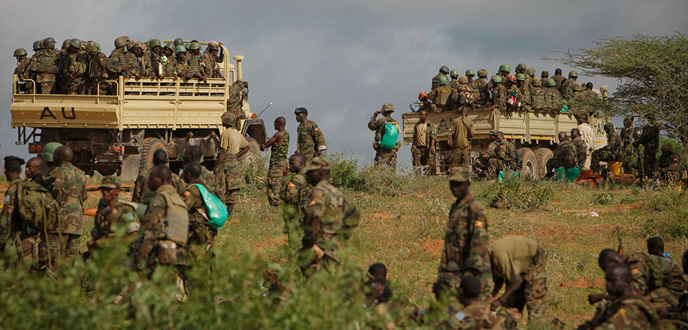 cc AMISOM Public Information, modified, AMISOM Public Information AMISOM & Somali National Army operation to capture Afgoye Corridor Day #5 03 Ugandan soldiers serving with the African Union Mission in Somalia (AMISOM) are seen on the the back of military trucks 25 May 2012 in the town of Afgoye to the west of the Somali capital Mogadishu as they prepare to deploy south of the town on the road to Merka. An joint-AMISOM and Somali National Army (SNA) offensive has driven the Al-Qaeda-affiliated extremist group Al Shabaab from the strategically important area of the Afgoye corridor, which the group used as a base to launch attacks inside Mogadishu and is also home to hundreds of thousands of refugees. With the extremists gone, the area is now secure for humantarian aid to reach the internally displaced peoples camps and opens the road between the agriculturally productive area of Afgoye and the Somali capital, allowing freedom of movement of goods, produce and people alike. AU-UN IST PHOTO / STUART PRICE.