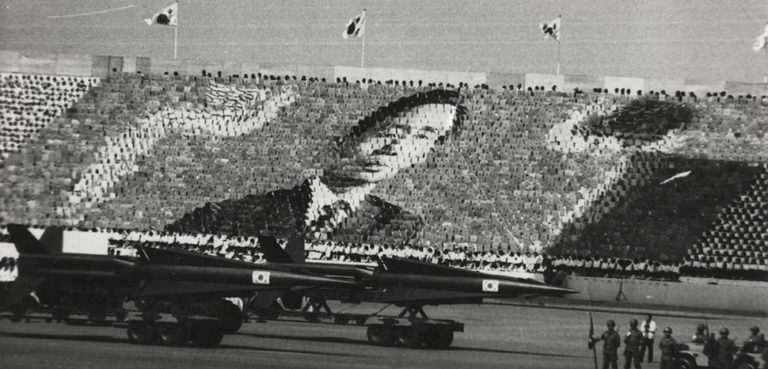 cc, Baek, Jong-sik, modified, English: South Korean Army parade at Armed Forces Day in 1973. A huge Card stunt which is honoring Park Chung-hee is being performed. https://en.m.wikipedia.org/wiki/File:Card_Stunt_for_Park_Chung-hee.jpg