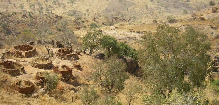 A village in Nuba, South Sudan, abandoned during an earlier civil conflict. cc Maureen Didde, modified, https://commons.wikimedia.org/wiki/File:Abandoned_Nuba_village.jpg