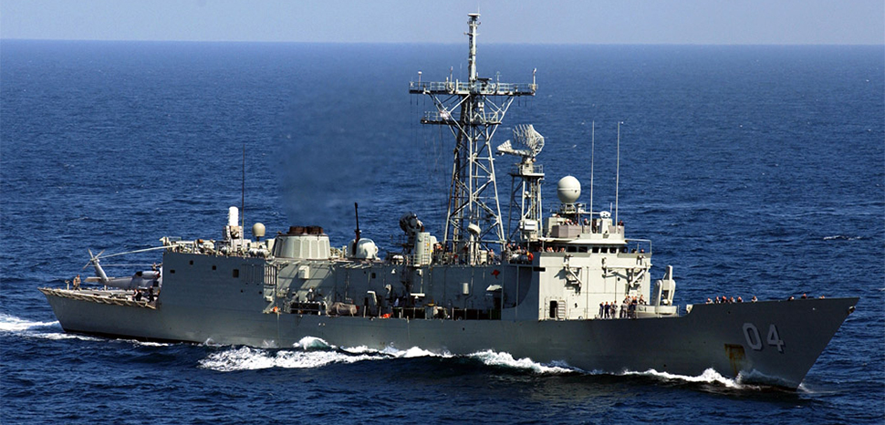 cc US Navy, modified, https://en.m.wikipedia.org/wiki/File:HMAS_Darwin_F-04.jpg / Persian Gulf (Mar. 15, 2005) — The Royal Australian Navy frigate HMAS Darwin (FFG 04) underway in the waters of the Persian Gulf alongside the Nimitz-class aircraft carrier USS Harry S. Truman (CVN 75). Darwin is a long-range escort with roles including area air defense, anti-submarine warfare, surveillance, reconnaissance and interdiction. She can counter simultaneous threats from the air, surface and sub-surface. The Truman Carrier Strike Group is on a regularly scheduled deployment in support of the Global War on Terrorism.